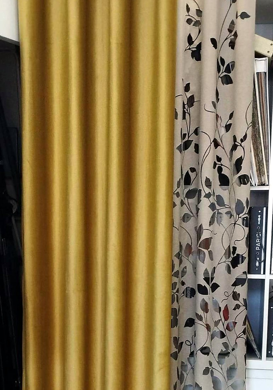 Tenda in velluto giallo accanto a una tenda con foglie